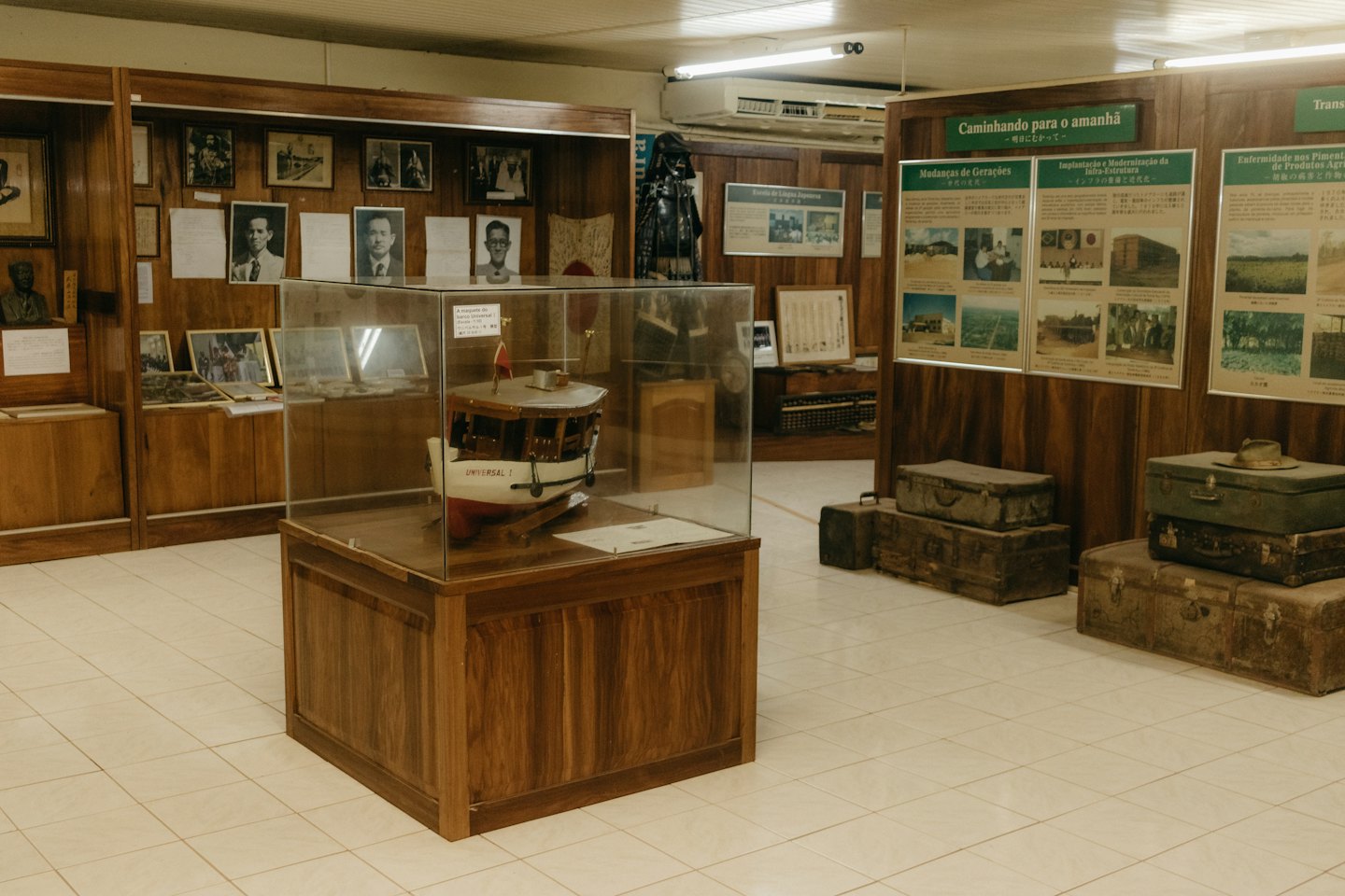 Model boat and vintage suitcases in a museum display.