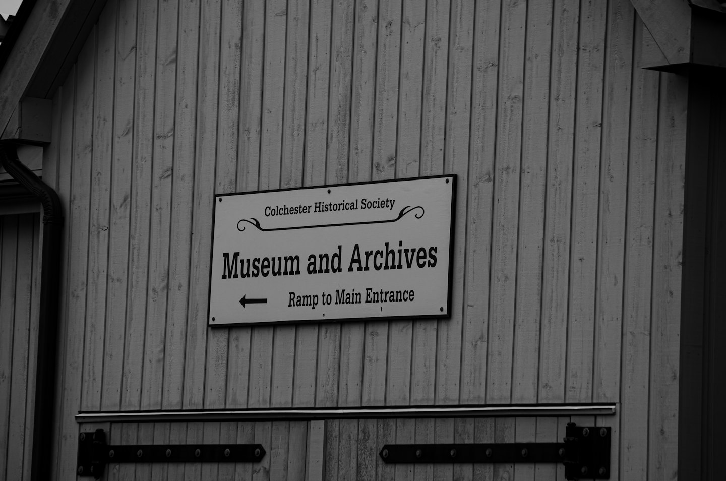 Colchester Historical Society sign on a wooden wall.